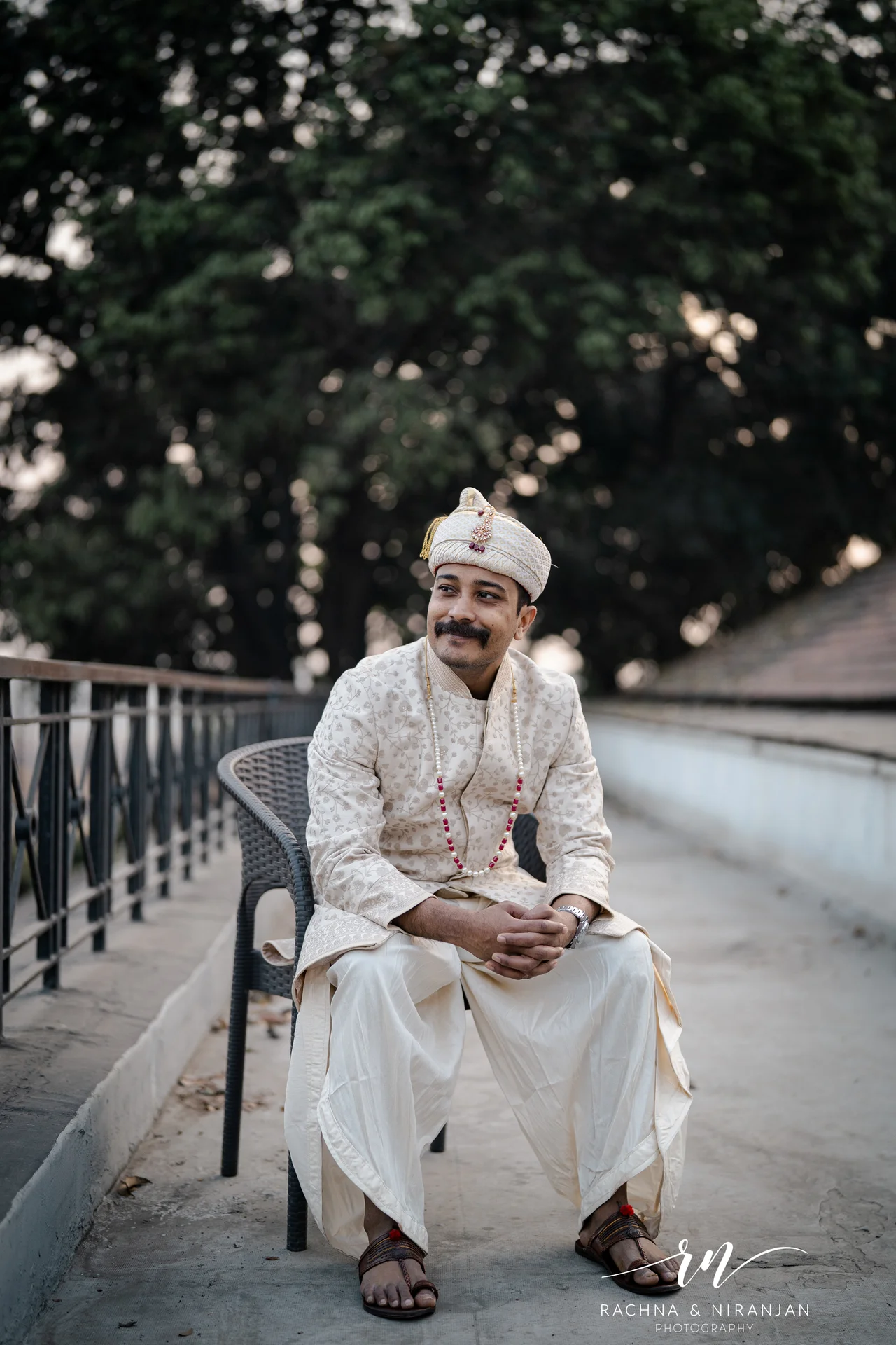 Groom in white kurta walking outdoors at Turf Club Pune — wedding photographer in Pune