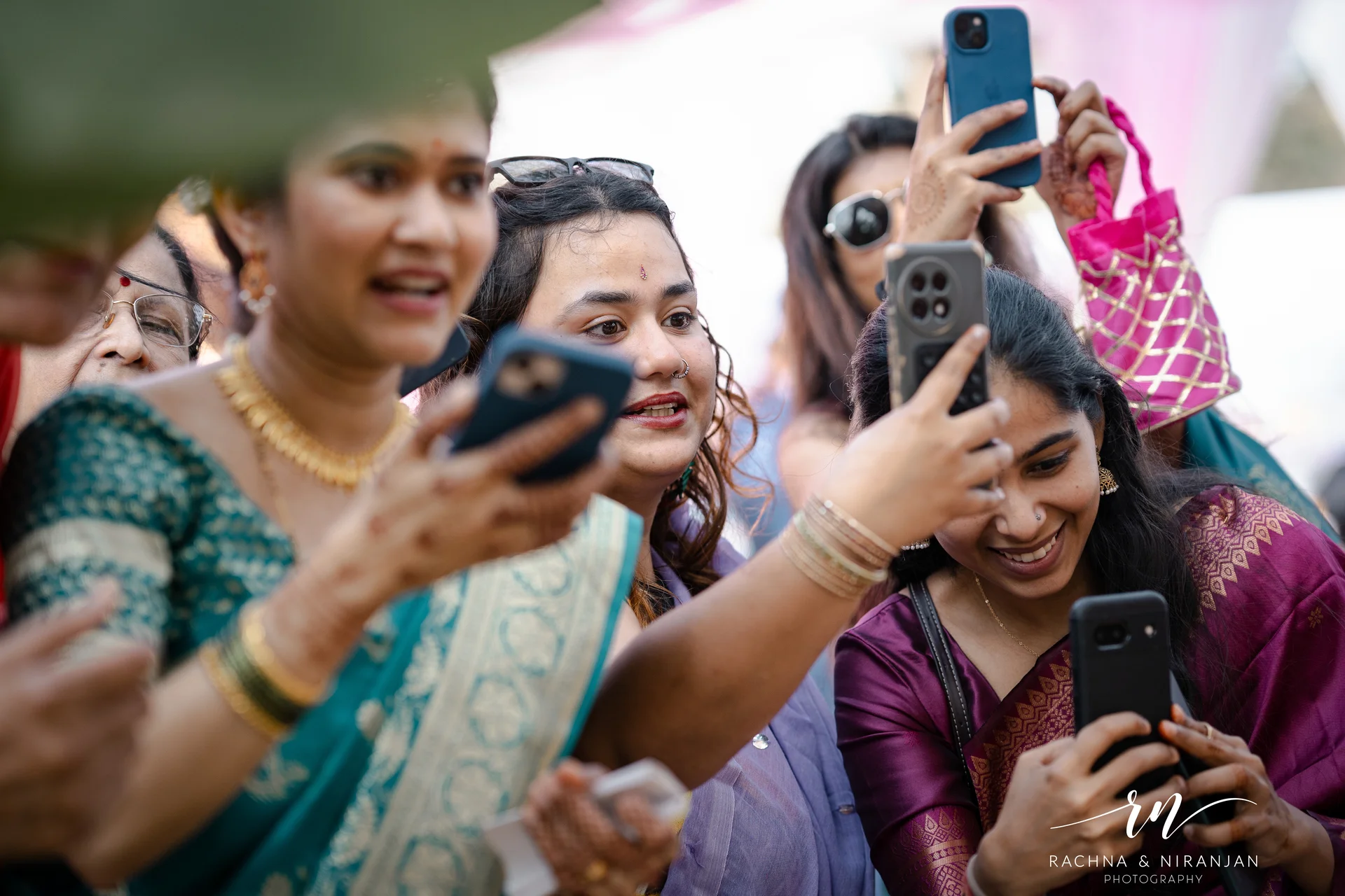 Guests laughing and capturing moments at outdoor wedding — candid wedding photographer Pune
